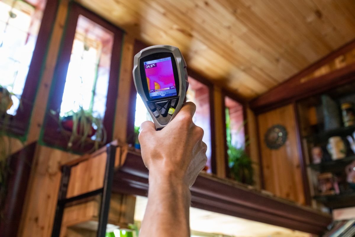 A person holds a thermal camera in a room, emphasizing the importance of air quality testing before mold removal.